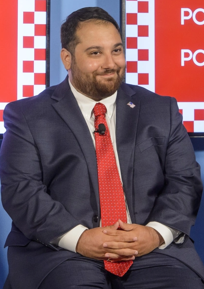 A photo of Peter Giunta sitting with his hands folded